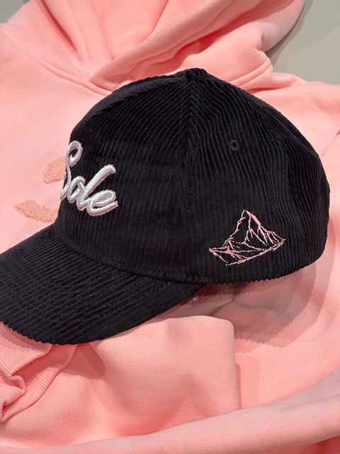 Side profile of the Sole Savaz corduroy snapback on a model, highlighting the pink mountain embroidery and the structured fit of the cap.