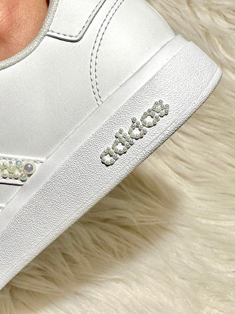 Custom Adidas sneakers with white silk ribbon laces and pearl embellishments.