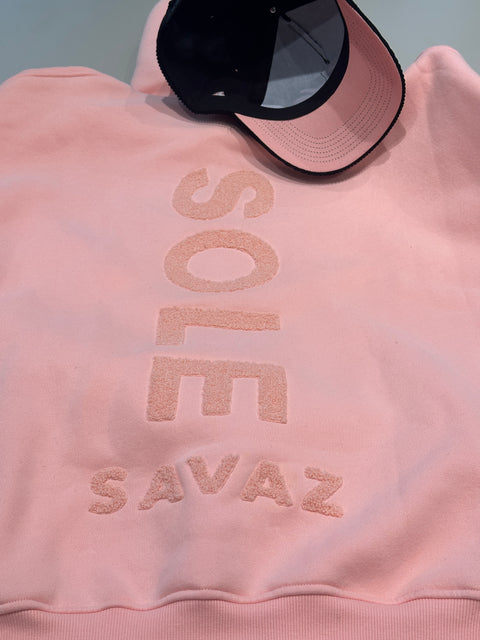 Top-down view of the Sole Savaz black corduroy snapback showing the premium pastel pink under-brim and a glimpse of the black satin interior lining for hair protection.